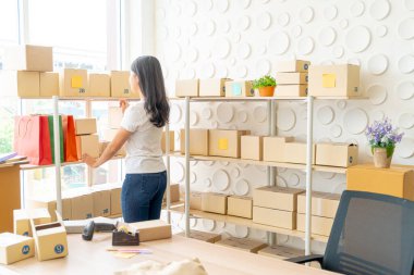 Asya kadın iş sahibi çalışan evde ambalaj kutusu ile w