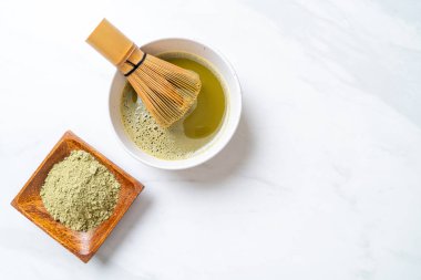 Yeşil çay tozu ve çırpılmış sıcak kibrit yeşil çay fincanı.