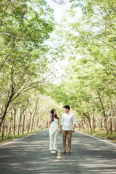 Gelukkige Aziatische paar verliefd op weg met boom boog — Stockfoto