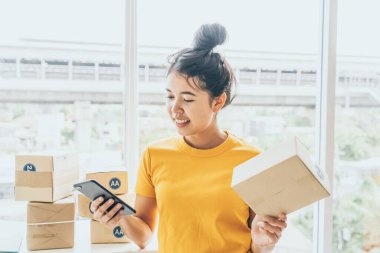 Asya kadın iş sahibi çalışan evde ambalaj kutusu ile w