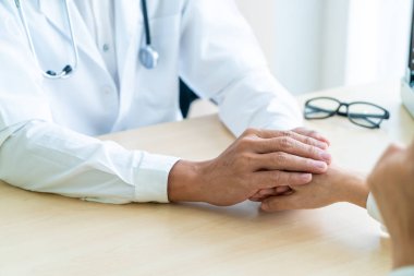 Doktorun eli kadın hastasına güvence veriyor.