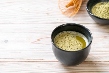 Yeşil çay tozu ve çırpılmış sıcak kibrit yeşil çay fincanı.