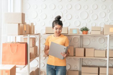  Genç Asyalı kadın ambar stok raf üzerinde mal kontrol