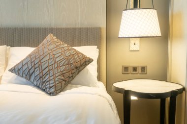 Yatak odasındaki beyaz yastıklar dekore edilmiş.