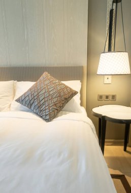 Yatak odasındaki beyaz yastıklar dekore edilmiş.