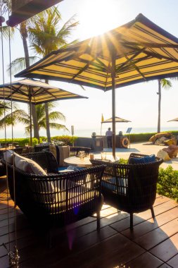 Açık teras güvertesi ve okyanus sahili arka planına sahip sandalye.