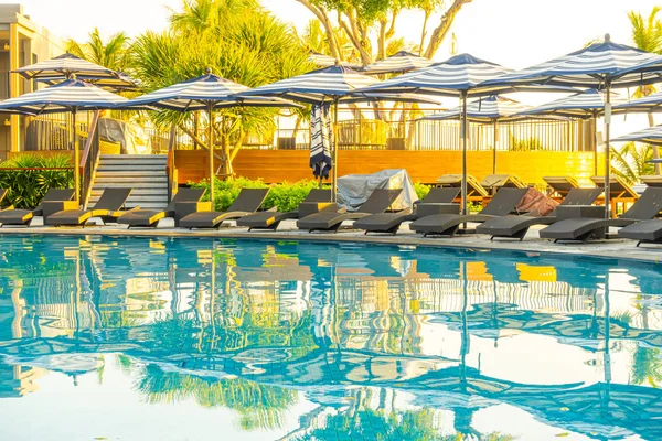 Parasol i łóżko basen wokół odkrytego basenu w hotelowym reso — Zdjęcie stockowe