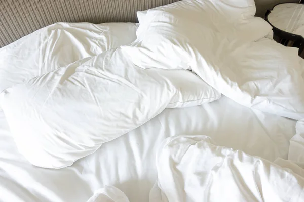 Travesseiro branco com cobertor na cama unmade — Fotografia de Stock