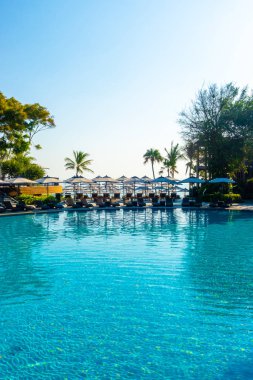 Havuz kenarında güzel bir havuz yatağı ve şemsiye.