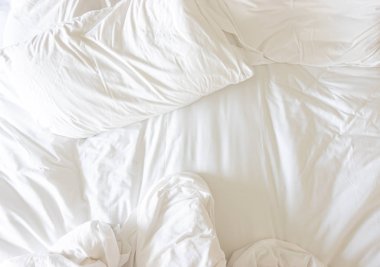 Yatağında battaniyesi olmayan beyaz yastık.