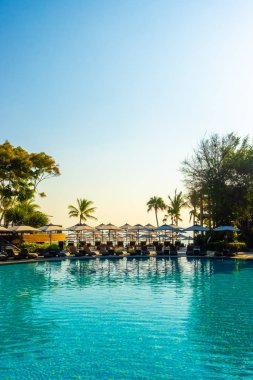 Havuz kenarında güzel bir havuz yatağı ve şemsiye.