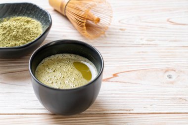 Yeşil çay tozu ve çırpılmış sıcak kibrit yeşil çay fincanı.