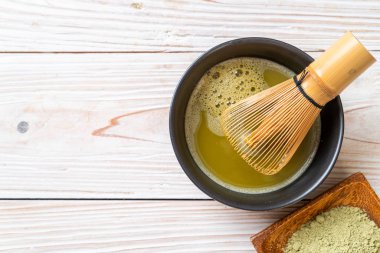 Yeşil çay tozu ve çırpılmış sıcak kibrit yeşil çay fincanı.