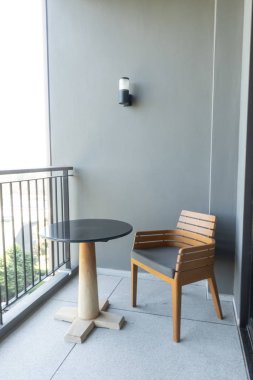 Tahta sandalye ve masa balkonda.