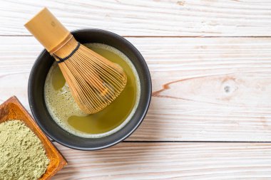 Yeşil çay tozu ve çırpılmış sıcak kibrit yeşil çay fincanı.