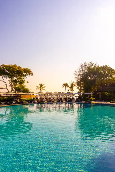 beautiful pool chair bed and umbrella around swimming pool in ho