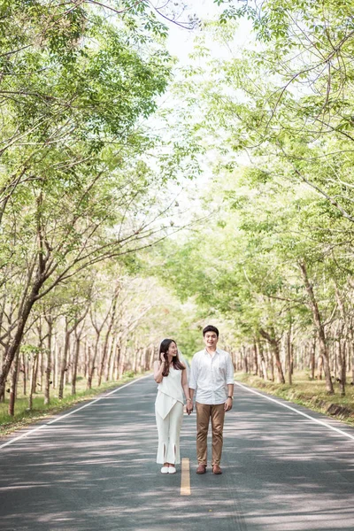 Heureux asiatique couple dans l'amour sur la route avec arbre arc — Photo