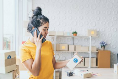 Asya kadın iş sahibi çalışan evde ambalaj kutusu ile w