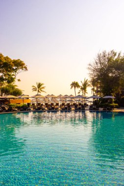 Havuz kenarında güzel bir havuz yatağı ve şemsiye.