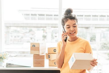 Asya kadın iş sahibi çalışan evde ambalaj kutusu ile w