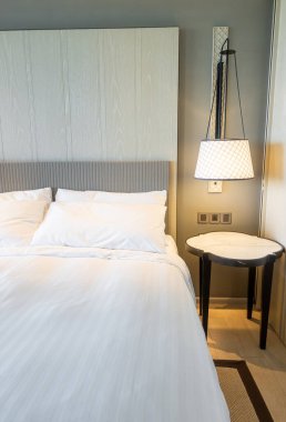 Yatak odasındaki beyaz yastıklar dekore edilmiş.