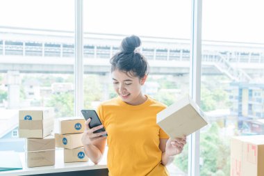 Asya kadın iş sahibi çalışan evde ambalaj kutusu ile w