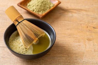 Yeşil çay tozu ve çırpılmış sıcak kibrit yeşil çay fincanı.