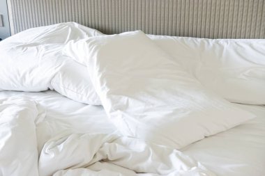 Yatağında battaniyesi olmayan beyaz yastık.