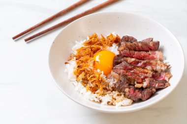 yumurta ile tepesinde pirinç kase dilimlenmiş sığır eti