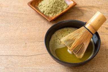 Yeşil çay tozu ve çırpılmış sıcak kibrit yeşil çay fincanı.