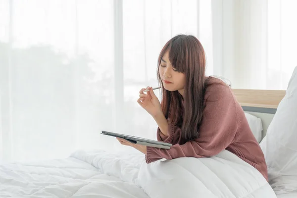 Asian women working with tablet on bed — 图库照片