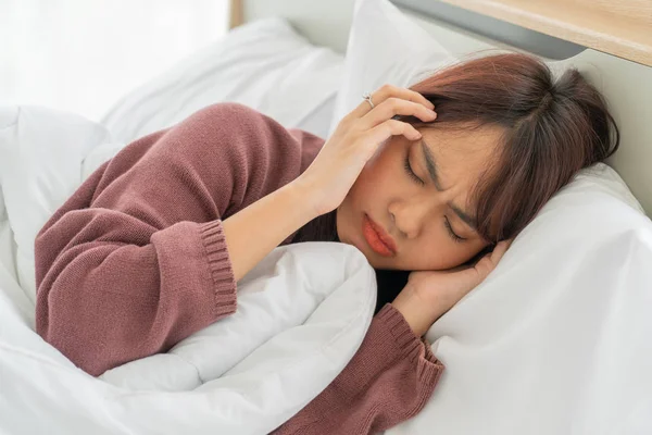 Wanita Asia sakit kepala dan tidur di tempat tidur — Stok Foto