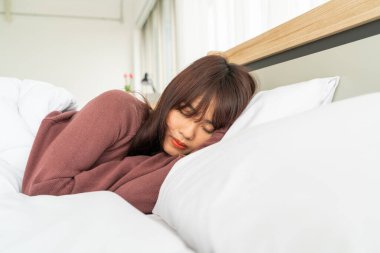 Asian woman sleeping on bed in morning