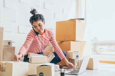 Asya kadın iş sahibi çalışan evde ambalaj kutusu ile w