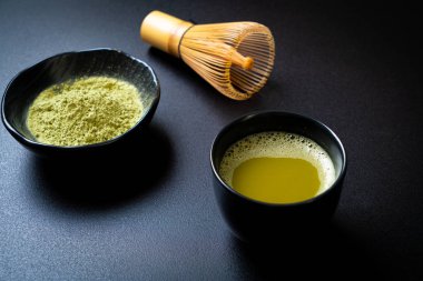 Yeşil çay tozu ve çırpılmış sıcak kibrit yeşil çay fincanı.