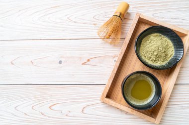 Yeşil çay tozu ve çırpılmış sıcak kibrit yeşil çay fincanı.