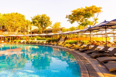 Seyahat ve tatil konsepti için otel tatil beldesinde yüzme havuzunda şemsiyesi ve sandalyesi olan güzel tropik plaj ve deniz.