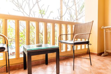 Otel odasındaki balkonda boş sandalye ve masa.