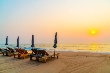 Okyanus geçmişi olan kumsalda boş bir plaj sandalyesi.