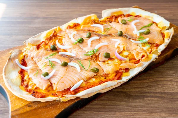 smoked salmon pizza on wood board - Italian food style