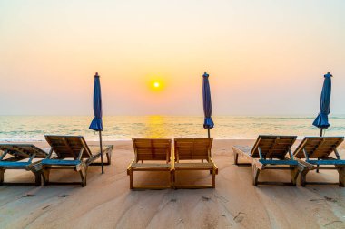 Okyanus geçmişi olan kumsalda boş bir plaj sandalyesi.