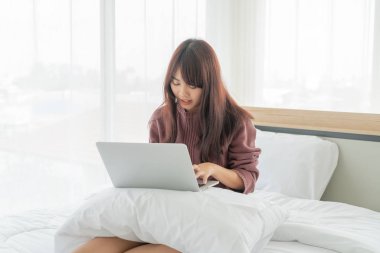 Evde dizüstü bilgisayarla çalışan Asyalı kadınlar.