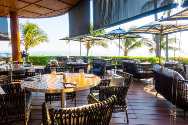 Seyahat ve tatil konsepti için okyanus sahili arka planına sahip bahçe terası ve sandalye.