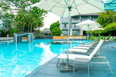 Tatil seyahati konsepti için deniz manzaralı havuzda yüzen şemsiye ve sandalye.