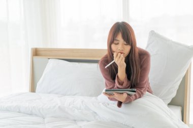 Yatakta tabletle çalışan güzel Asyalı kadınlar