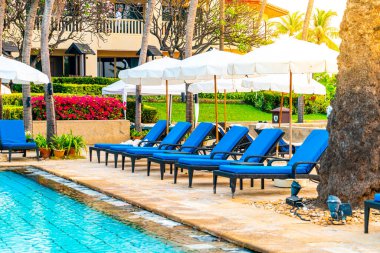 Otelde ve tatil beldesinde yüzme havuzunda güzel şemsiye ve sandalye - tatil ve tatil konseri