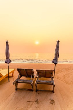 Okyanus geçmişi olan kumsalda boş bir plaj sandalyesi.