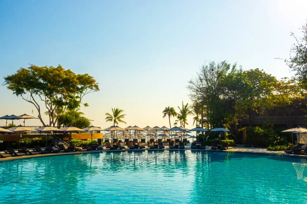 beautiful pool chair bed and umbrella around swimming pool in hotel resort  for travel and vacation concept