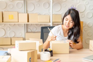 Küçük işletme sahibi, kadın dizüstü satın alma siparişkontrol ve paket kutusuna teslim yazmak - online veya online alışveriş konsepti satmak