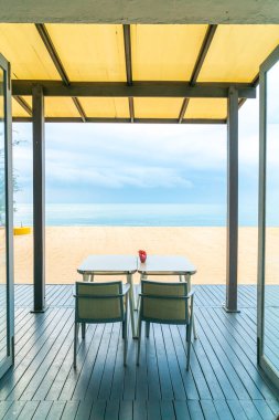 Deniz sahili geçmişi olan restoranda boş bir yemek masası.